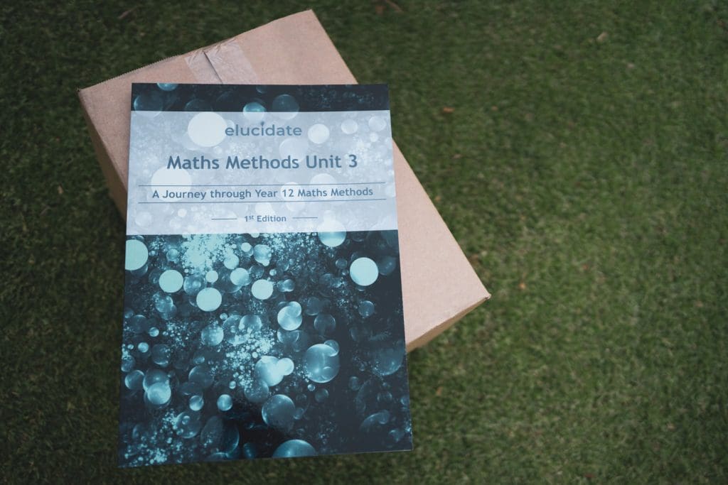 Maths textbook on a cardboard box on grass