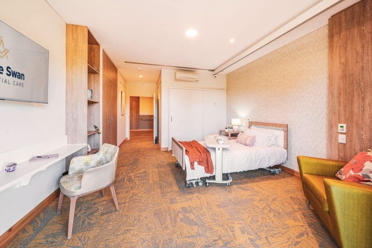 Aged care suite with bed and bathroom in background